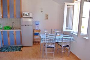 uma cozinha com uma mesa com cadeiras e um frigorífico em Apartment in Privlaka with Terrace, Air conditioning, WIFI, Washing machine (4839-2) em Privlaka