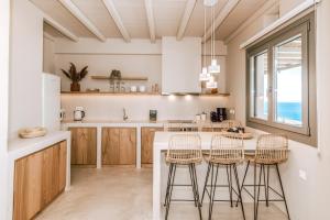 een keuken met een groot eiland met barkrukken bij Casa Eutopia in Agios Romanos