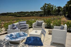 un patio con tavolo, sedie e vista su un campo di Tenuta l'Alba di Monte Matino - Mobil Home a Otranto