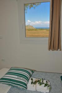a bed with a pillow and a window with a view at Tenuta l'Alba di Monte Matino - Mobil Home in Otranto