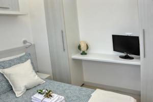 a bedroom with a bed with a tv on a shelf at Tenuta l'Alba di Monte Matino - Mobil Home in Otranto