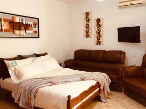 - une chambre avec un lit et un canapé dans l'établissement Flora Apartments Sarande, à Saranda