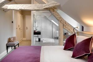 a bedroom with a large bed with purple pillows at Le Manoir Les Minimes in Amboise