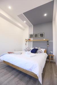 a bedroom with a large bed with white sheets at hotelise I Tulip Apartment in Yerevan