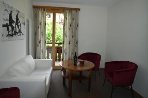 uma sala de estar com um sofá branco e uma mesa em Hotel Cabana em Grindelwald