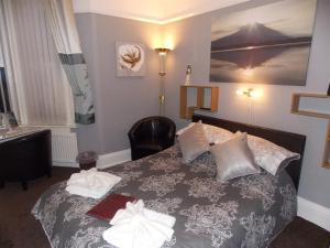 1 dormitorio con 1 cama con 2 toallas en Easton Court Guest House, en Paignton