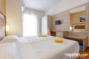 Hotel Castell - Montagnoli Group في ليموني سول غاردا: غرفة نوم بسرير كبير عليها مناشف صفراء