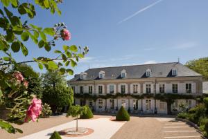 une grande maison avec un jardin en face de celle-ci dans l'établissement Le Manoir Les Minimes, à Amboise
