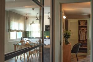 Apartamentos Boutique Fuente Real في كوميلاس: مطبخ وغرفة طعام مع طاولة وكراسي