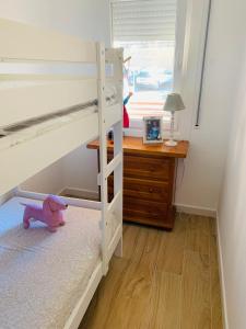 a bedroom with a bunk bed with a desk and a purple bear at Sta Maria Apartment in Tamariu