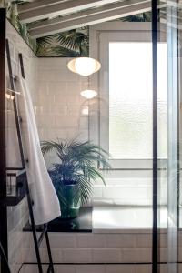 Apartamentos Boutique Fuente Real في كوميلاس: حمام به بوتقة الفخار ونافذة