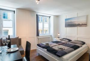 1 dormitorio con 1 cama grande y mesa de comedor en HITrental Schmidgasse - Apartments en Zúrich