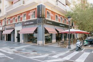 un edificio en una calle de la ciudad con mesas y sillas en The Little Corner B&B, en Valencia