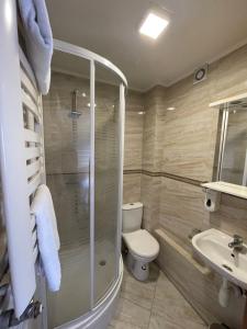 a bathroom with a shower and a toilet and a sink at Hotelik Gold in Raszyn