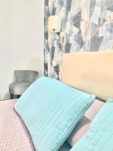 un letto con un cuscino blu e una sedia di Residence Diaz a Como