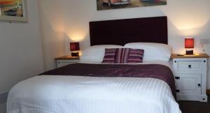 a bedroom with a large bed with two night stands at Links Side Guest House in Bude