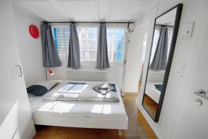 Dormitorio pequeño con cama y espejo en HITrental Schmidgasse - Apartments en Zúrich