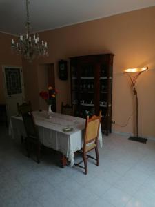 una sala da pranzo con tavolo, sedie e lampadario pendente di Antica Dimora del Sole a Licata