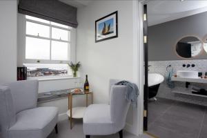 a bathroom with two chairs and a table and a sink at Leader, Maritime Suites, Brixham in Brixham