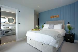 a bedroom with a large bed and a bathroom at Leader, Maritime Suites, Brixham in Brixham