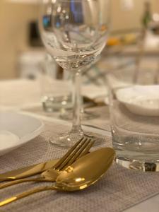 a table with silverware and a wine glass on it at Vicky - New Apartment Centrum Srodmiescie in Warsaw