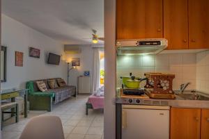 a kitchen and a living room with a couch at Boutique Seafront Suites in Zakynthos