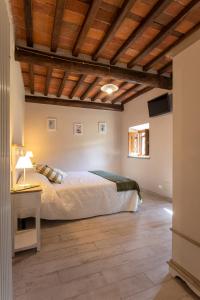 ein Schlafzimmer mit einem Bett und einer Holzdecke in der Unterkunft Garden Relays Villa Rosy in Massarosa