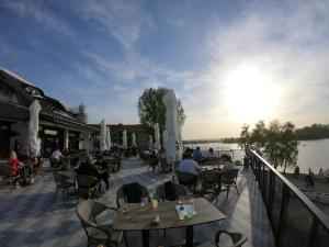 a group of people sitting at tables on a patio at Prenoćište Srebrno Jezero in Veliko Gradište