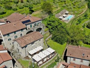 - une vue aérienne sur un vieux bâtiment avec une piscine dans l'établissement Agriturismo Casa Turchetti, à Comano