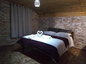 a bedroom with a bed with a ribbon on it at Pousada Duplátanos in Monte Verde