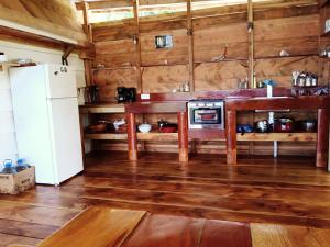 cocina con suelo de madera y nevera en Sunset Double rooms - Auberge Polynésienne en Tevaitoa