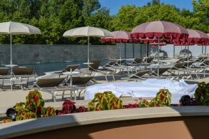 a group of lawn chairs and umbrellas at Hotel Baffo Rosso in Alba Adriatica