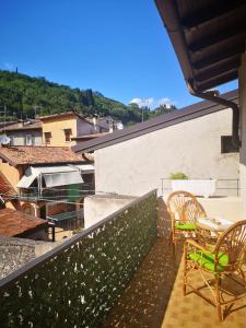 a balcony with chairs and tables on a building at Casa Caterina 2 storey house, with a mountain view in Toscolano Maderno