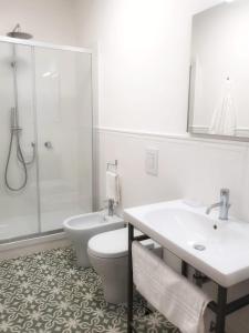 a white bathroom with a toilet and a shower at Palazzo La Piana Rooms in Catania