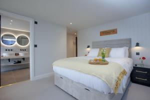 a bedroom with a bed with a tray of fruit on it at Vigilance, Maritime Suites, Brixham in Brixham