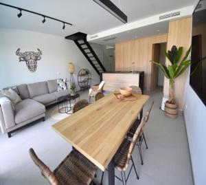 een woonkamer met een houten tafel en stoelen bij Apartamento Estrasburgo Suites Javea - 5044 in Jávea