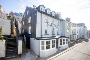 a man sitting on the roof of a white building at Vigilance Suite - Free Wi-Fi - Sea View in Brixham +11 photos