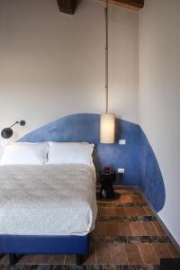 a bed with a blue headboard in a room at Il Poggio di Musignano in Musignano