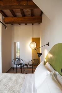 1 dormitorio con 1 cama, mesa y sillas en Il Poggio di Musignano en Musignano