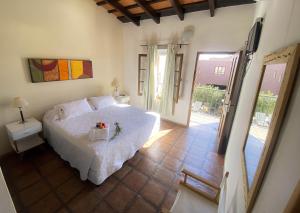 een slaapkamer met een wit bed en een balkon bij Hotel Plaza Cafayate in Cafayate