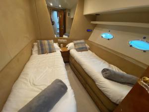 two beds in a small room with a sink at Luxury Italian Motor Yacht in Hamble