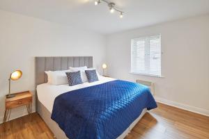 a bedroom with a large bed with a blue blanket at Host & Stay - Freshwater View in Whitby