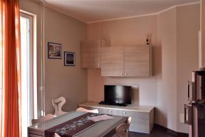 a small room with a desk with a tv and a table at Le Vele Residence in Pietra Ligure