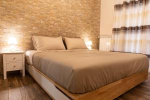 a bedroom with a large bed and a brick wall at Tizzy Apartment & Rooms in Bari