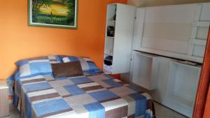 - une petite chambre avec un lit et un réfrigérateur dans l'établissement GARATUCAIA - Suites Casa de Madeira, à Angra dos Reis