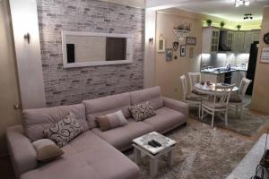 a living room with a couch and a dining room at Lux Apartment Rose in Kragujevac
