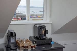 uma máquina de café sentada numa mesa ao lado de uma janela em Provident, Maritime Suites, Brixham em Brixham
