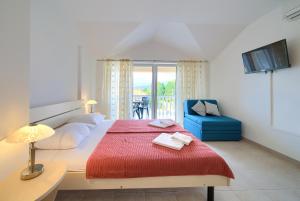 een slaapkamer met een groot bed en een rode deken bij Apartments Ivica Krk Island in Šilo