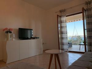 een woonkamer met een tv en een tafel bij Omiš Relaxing Sea Lounge in Marusici 
