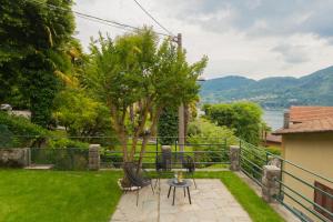 特雷梅佐的住宿－Enchanted Como Lake - Tremezzo Apartments by Rent All Como，一个带桌椅的庭院,享有水景